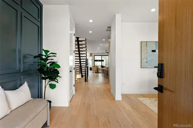 a hallway with wooden floor and a potted plant