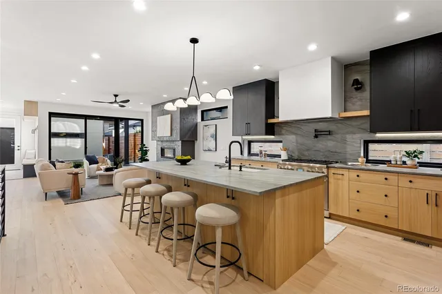 a large kitchen with kitchen island a island a sink stainless steel appliances and cabinets