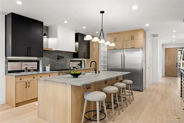 a kitchen with stainless steel appliances granite countertop a sink a stove and a refrigerator