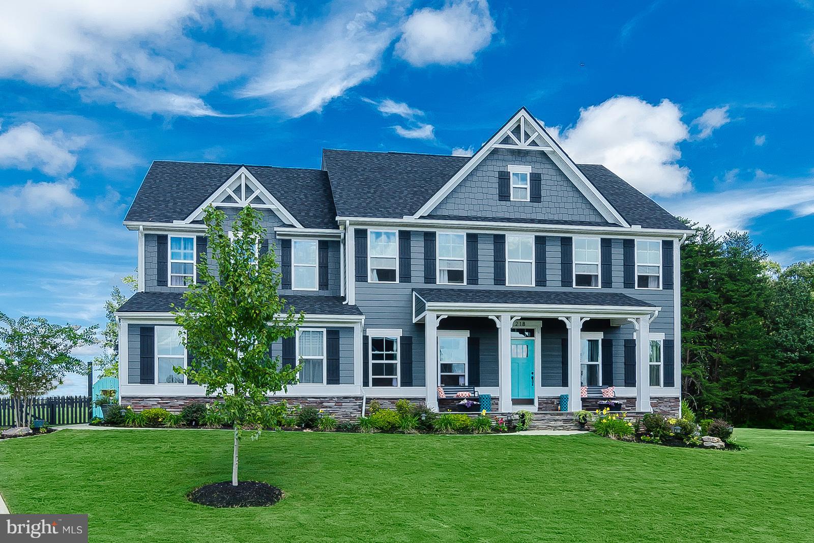 a front view of a house with garden and trees