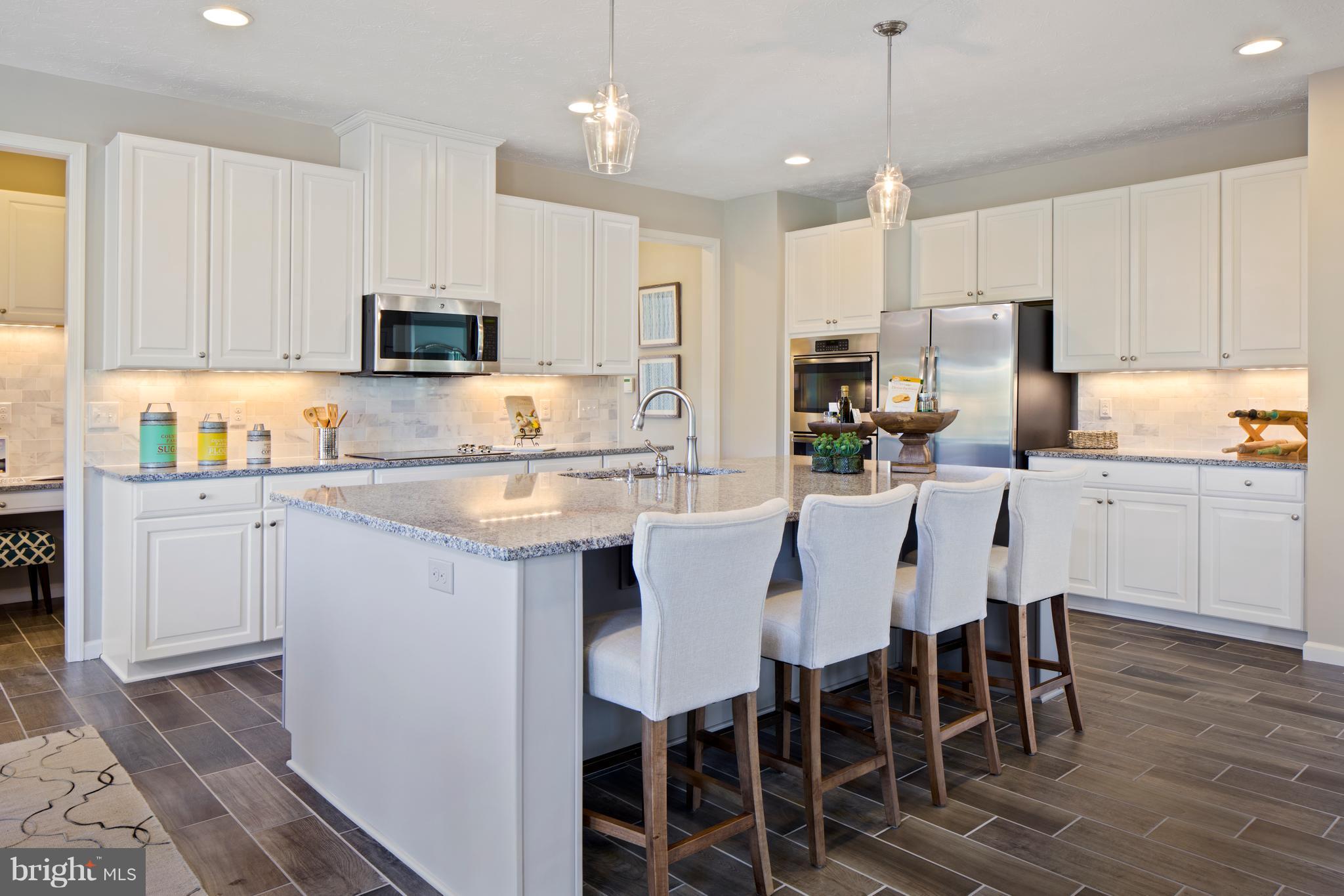 3118 Roderick Road Frederick, MD 21704 - Photo 7 of 25 a kitchen with kitchen island granite countertop a table chairs microwave and cabinets