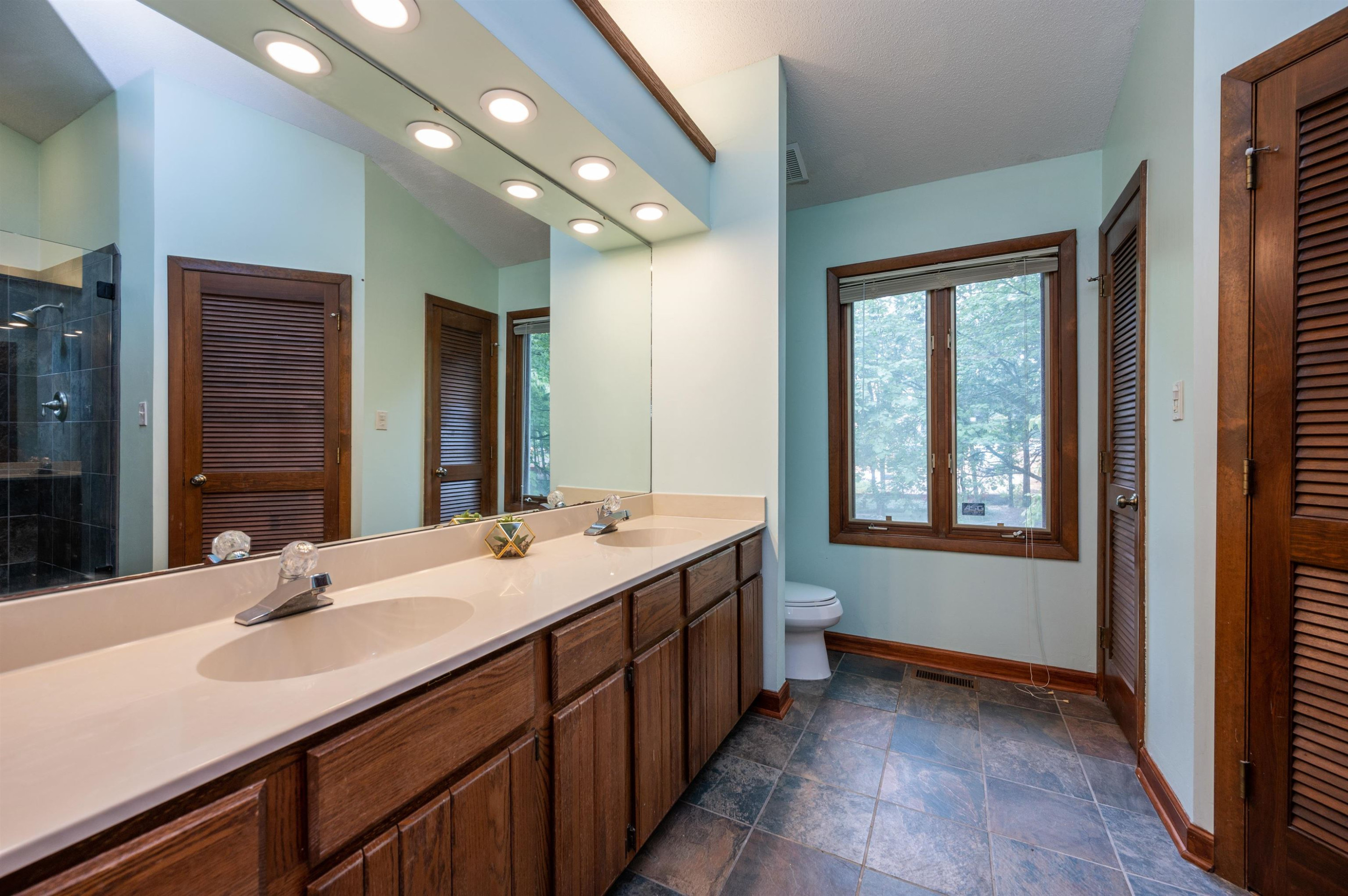 4321 Southwind Drive Raleigh, NC 27613 - Photo 21 of 31 Featuring dual vanities, walk-in closet, and updated tile shower! Primary Bath