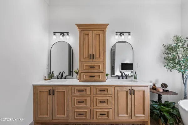 a bathroom with double vanity and a mirror