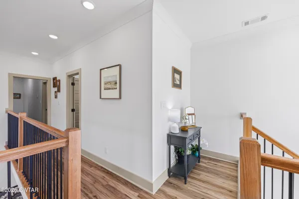 a view of a hallway with wooden floor and stairs