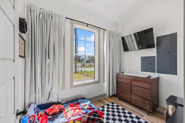 a bedroom with a bed and wooden floor