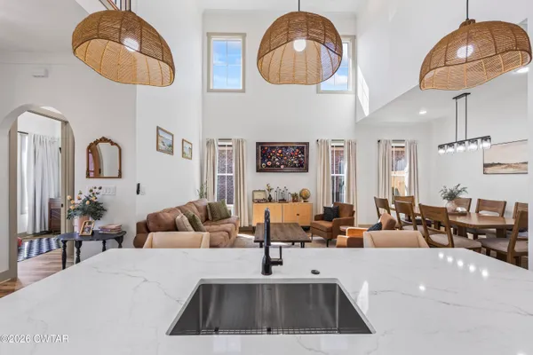 a room with lots of white furniture and a chandelier