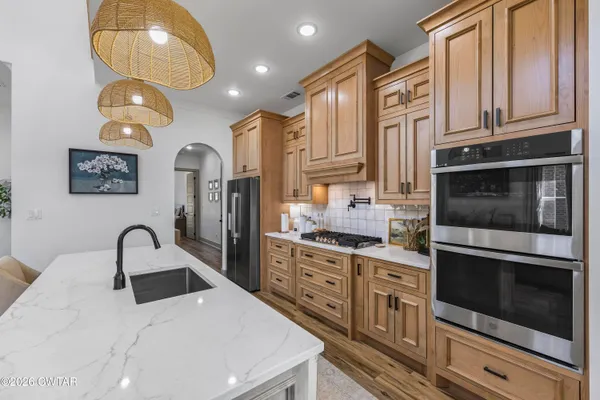 a kitchen with stainless steel appliances granite countertop a stove a sink and a microwave