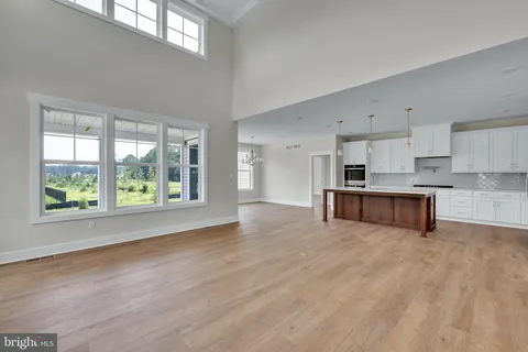 a large kitchen with stainless steel appliances granite countertop a stove a sink a refrigerator and a large window