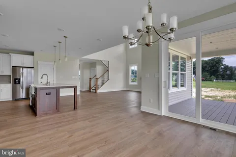 a view of a room with wooden floor and a kitchen