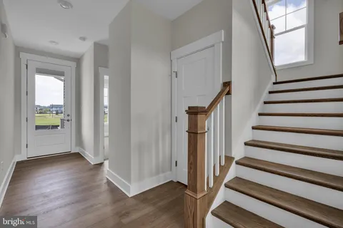 a view of entryway with wooden floor and stairs