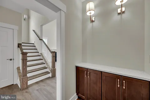 a view of a hallway with stairs and wooden floor