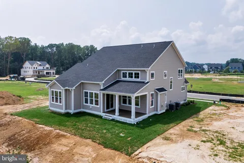 a view of a house with a big yard plants and large trees