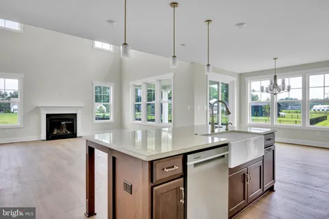 a kitchen with a sink stove and wooden floor