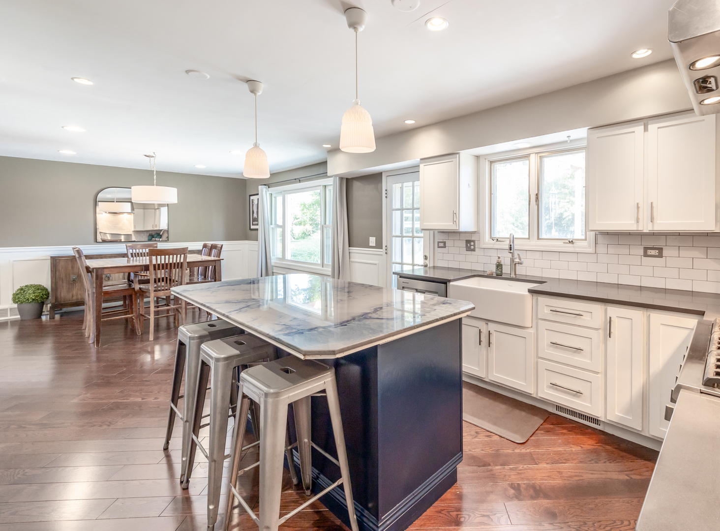 1223 Ridgeway Drive Elgin, IL 60123 - Photo 14 of 40 a kitchen with stainless steel appliances kitchen island granite countertop a stove a sink a dining table and chairs with wooden floor