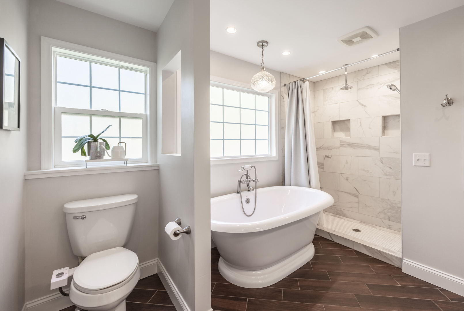 1223 Ridgeway Drive Elgin, IL 60123 - Photo 22 of 40 a bathroom with a white tub sink toilet a mirror and a window