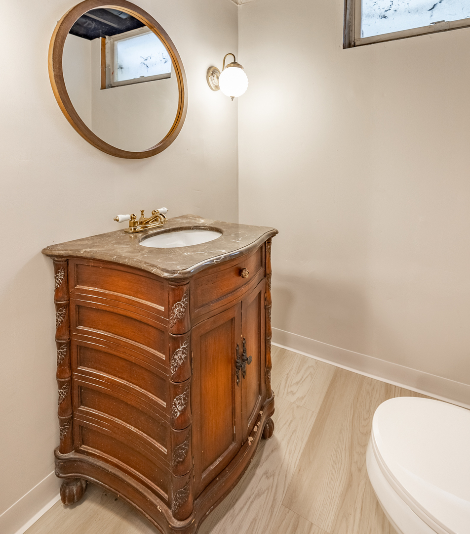 1223 Ridgeway Drive Elgin, IL 60123 - Photo 36 of 40 a bathroom with a sink a mirror and a toilet