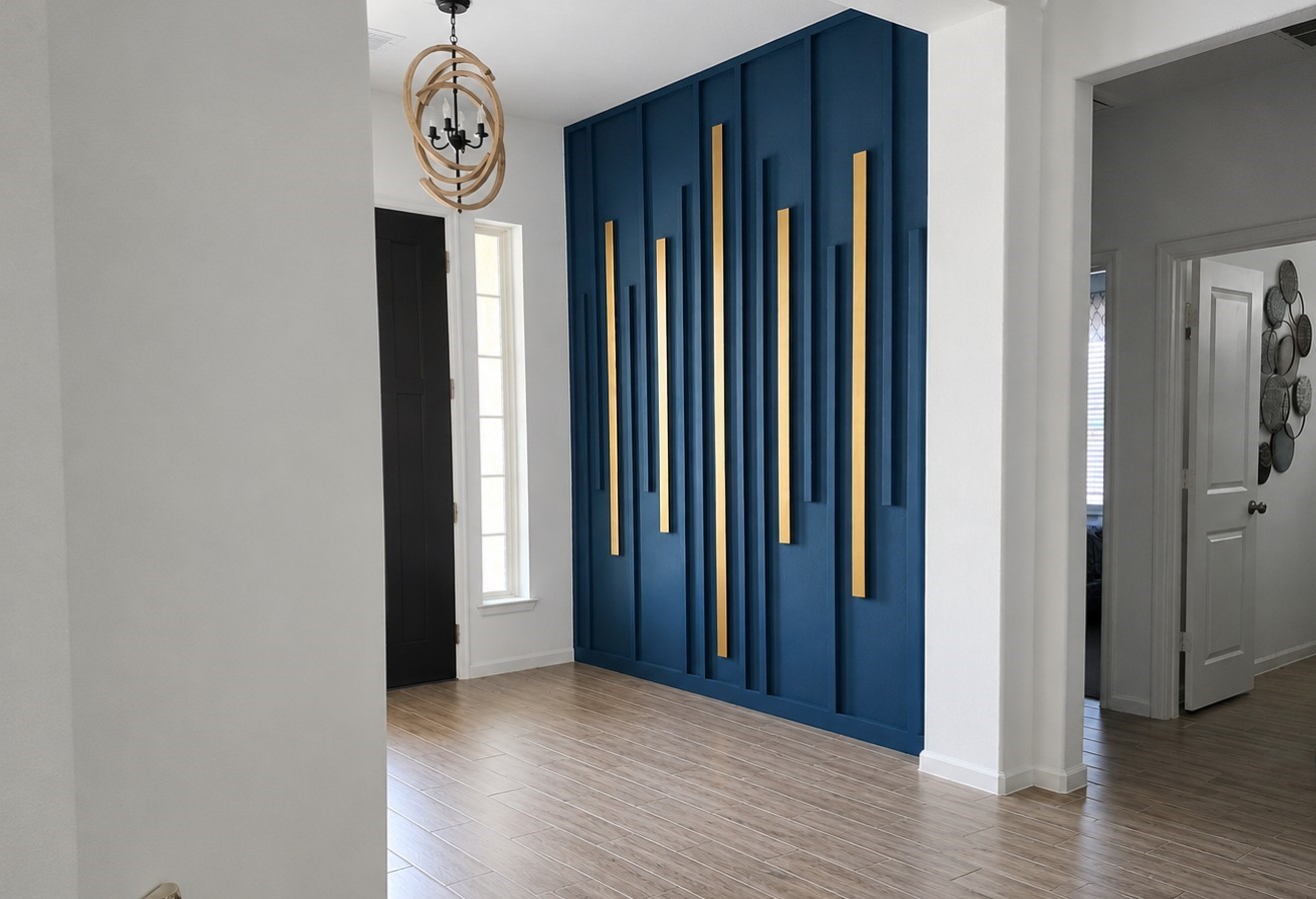 5035 Sierra Ridge Drive Rosenberg, TX 77469 - Photo 2 of 26 Step into elegance with this stunning entryway, featuring a striking blue accent wall with gold details and a chic chandelier that sets the tone for modern sophistication.