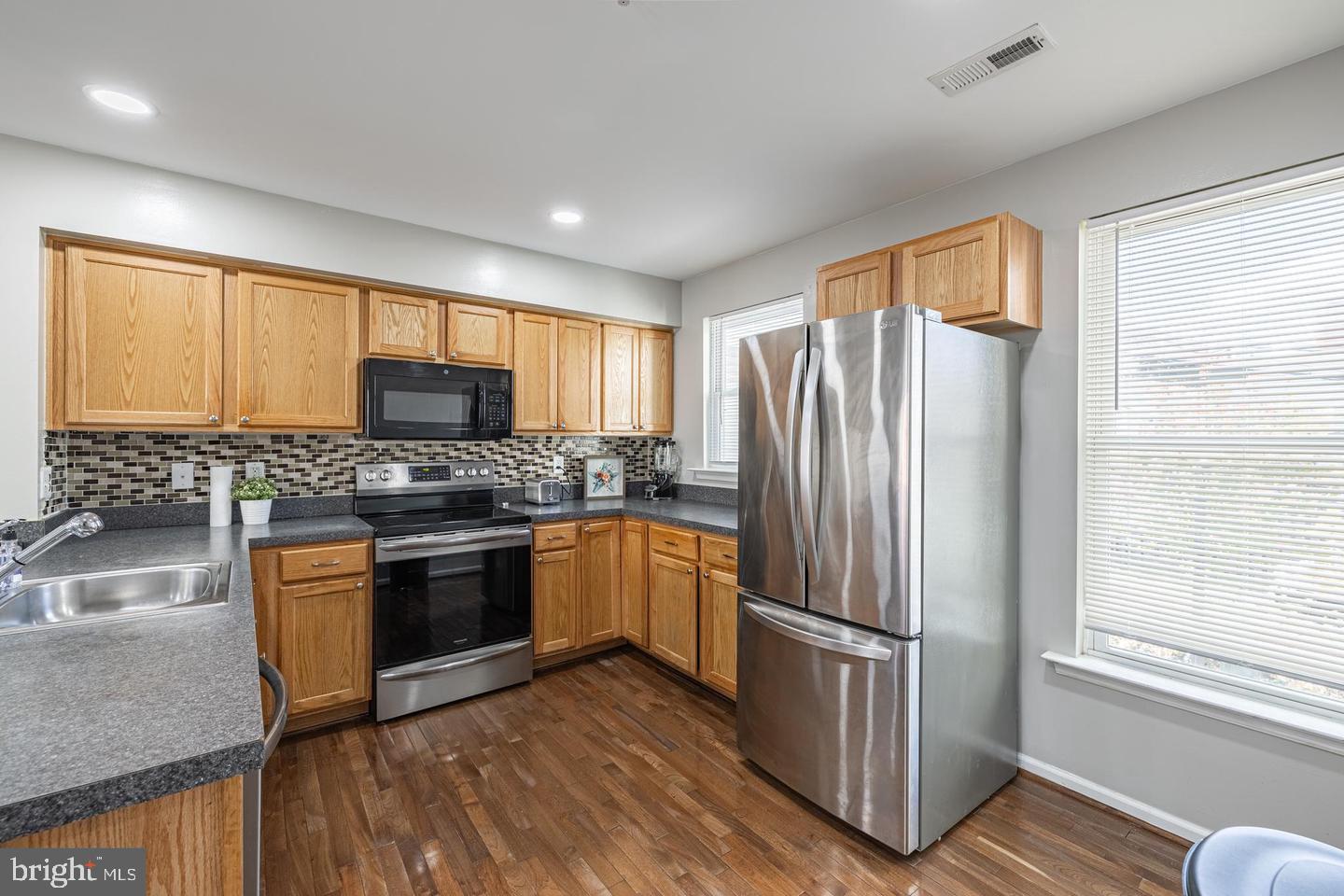 1021 3rd Place Southeast Washington, DC 20003 - Photo 17 of 29 a kitchen with granite countertop stainless steel appliances a refrigerator cabinets and wooden floor