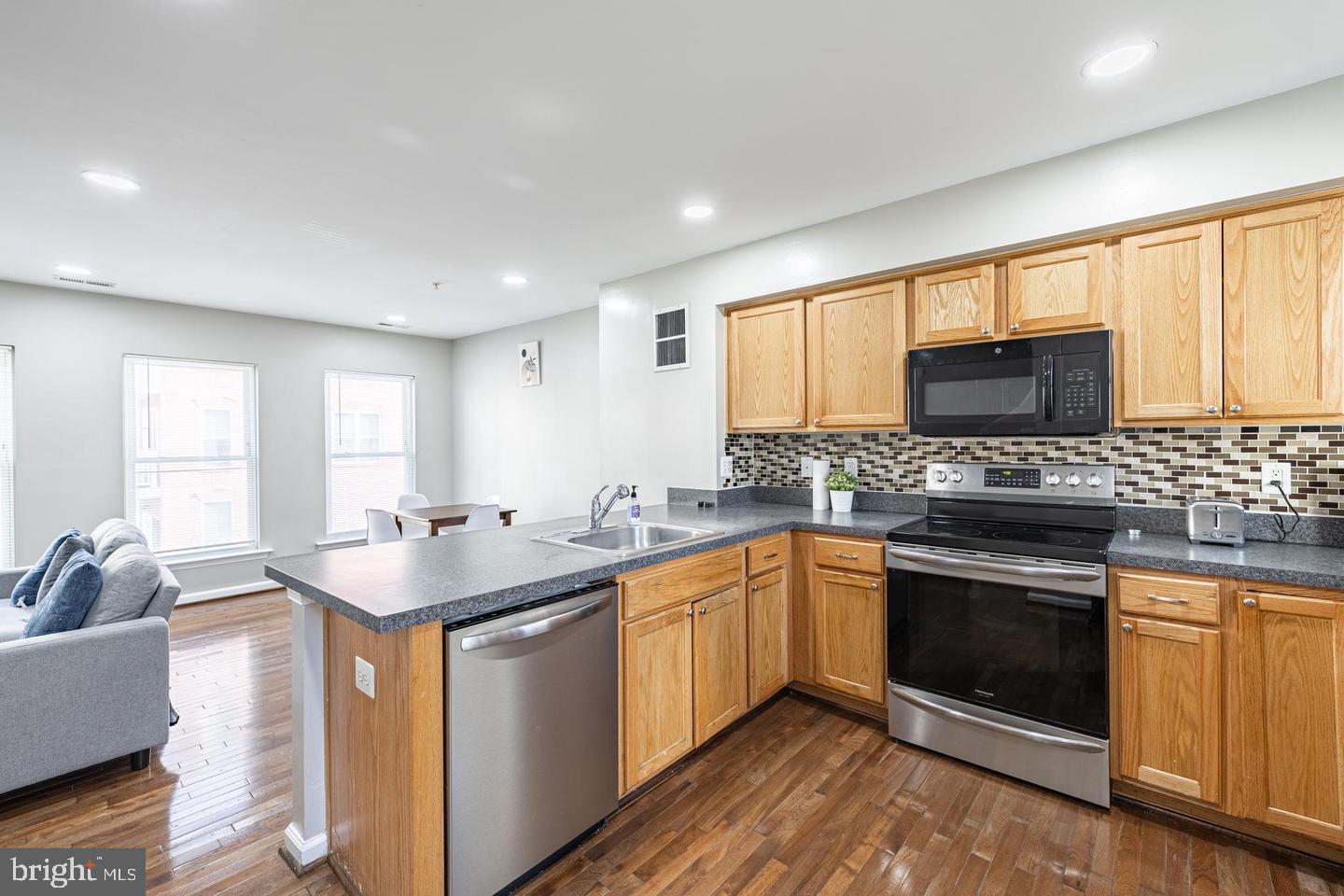 1021 3rd Place Southeast Washington, DC 20003 - Photo 18 of 29 a kitchen with stainless steel appliances granite countertop a sink stove and microwave