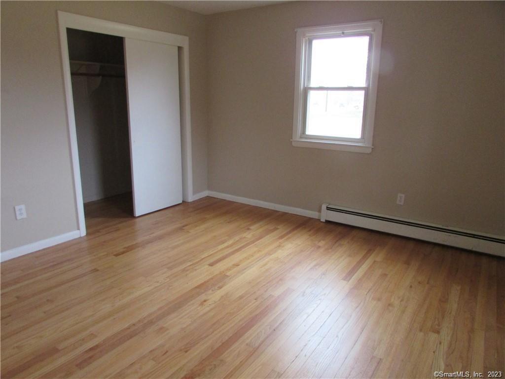 235 Shaker Road Enfield, CT 06082 - Photo 10 of 15 an empty room with wooden floor and windows