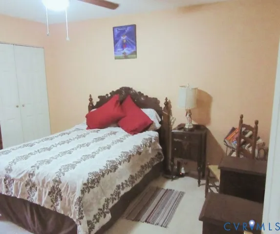 a bedroom with a bed and a flat tv screen on the dresser