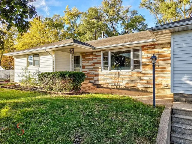 a front view of a house with a yard and potted plants