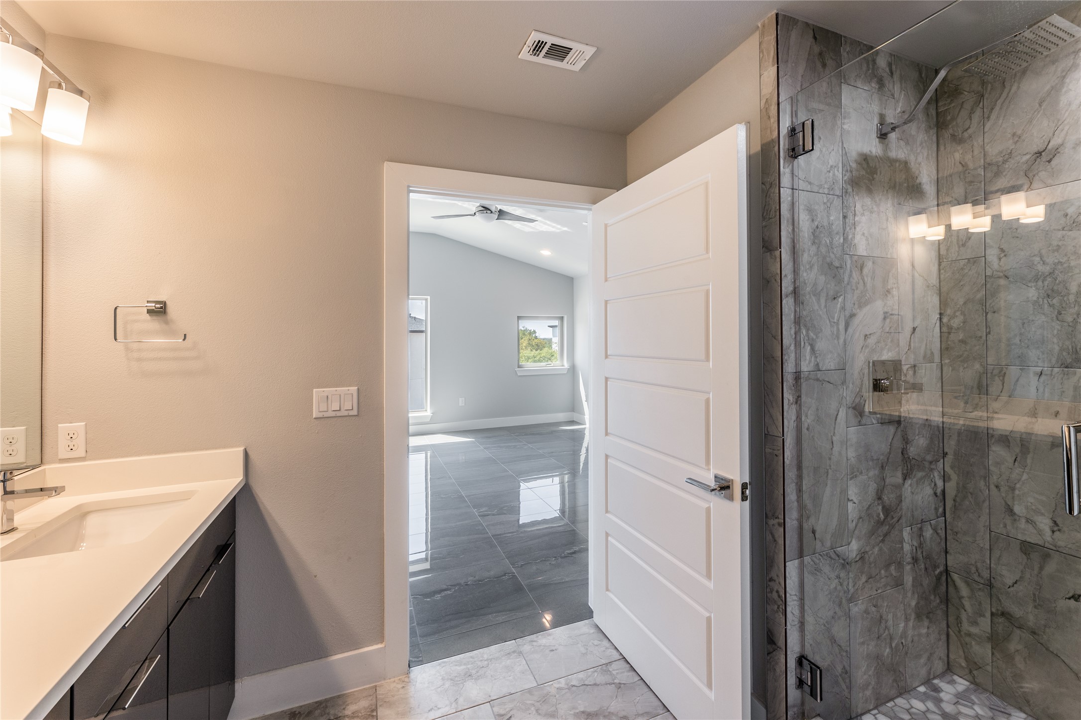 1417 Kramer Lane, Unit 9 Austin, TX 78758 - Photo 39 of 40 Full bath featuring light marble finish flooring, vanity, a marble finish shower, a ceiling fan, and vaulted ceiling