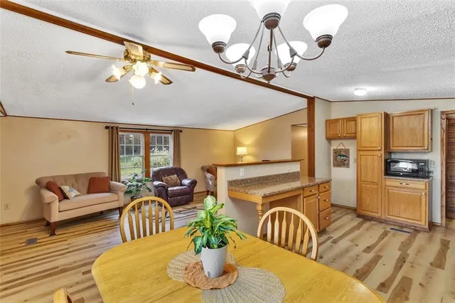 a dining room with furniture a chandelier and wooden floor
