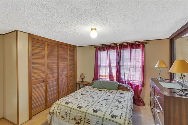 a bedroom with a bed dresser and a window