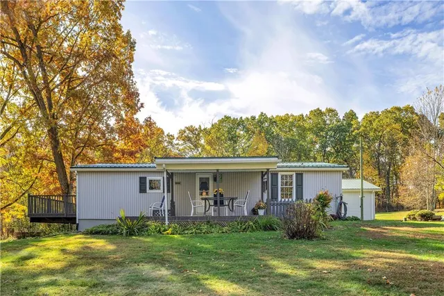 a view of a house with a yard and a large tree