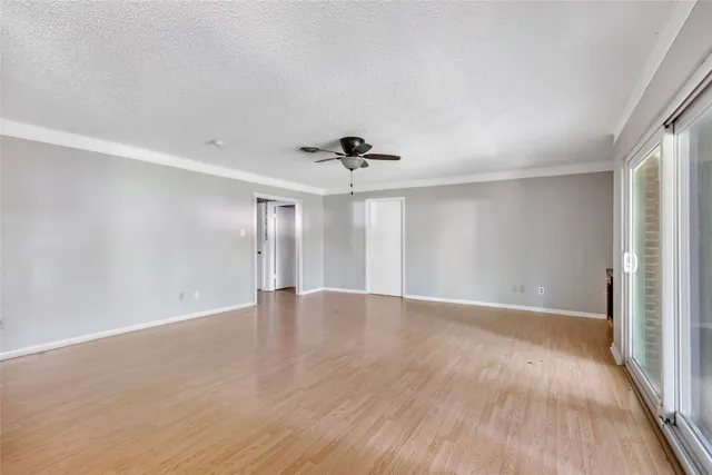 a view of a kitchen and an empty room with a window