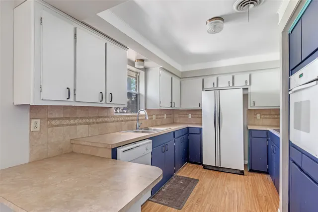 a kitchen with kitchen island a counter top space cabinets and refrigerator