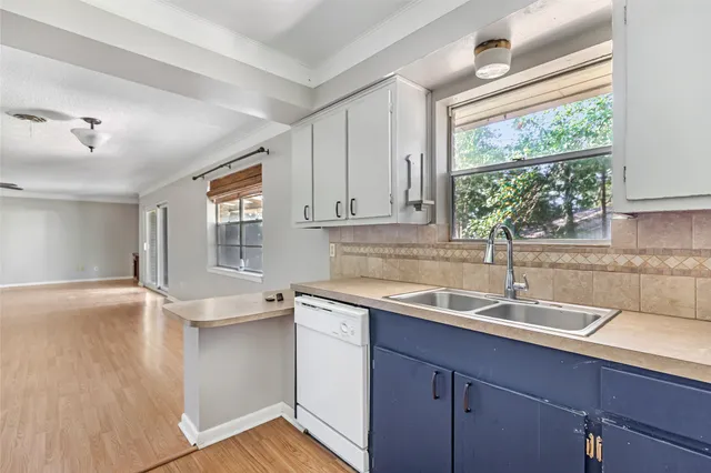 a view of empty room with wooden floor and windows