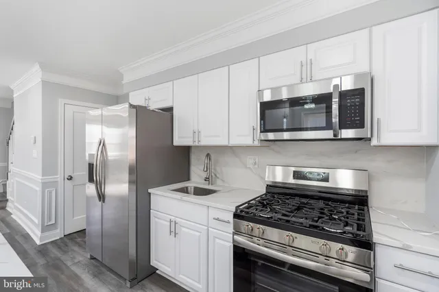 a large white kitchen with stainless steel appliances