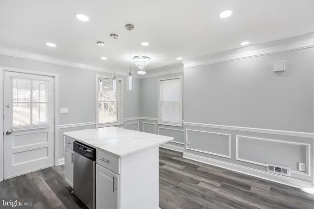 a kitchen with stainless steel appliances granite countertop white cabinets a refrigerator a stove a microwave oven with white cabinets