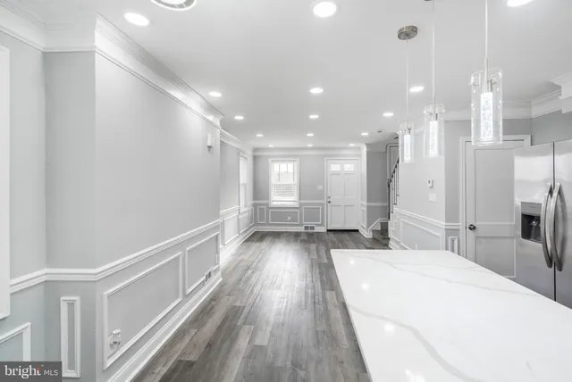 a kitchen with a sink chandelier and wooden floor