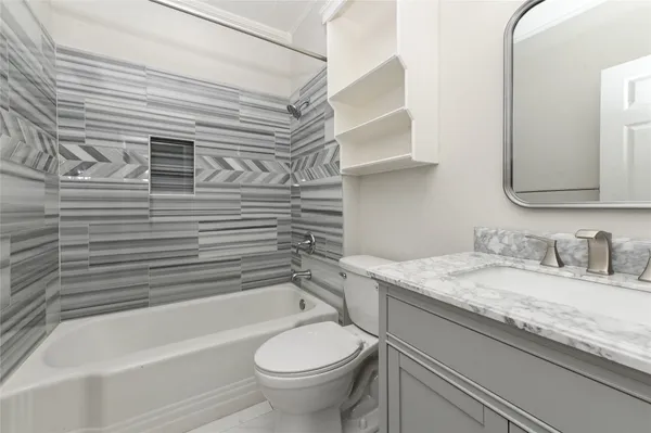 a bathroom with a granite countertop sink toilet and bathtub
