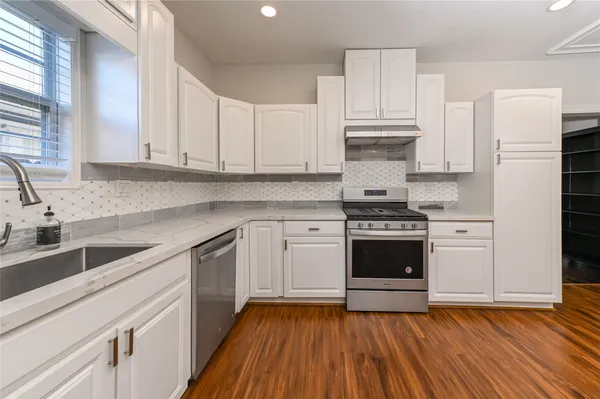 a kitchen with granite countertop white cabinets and white appliances