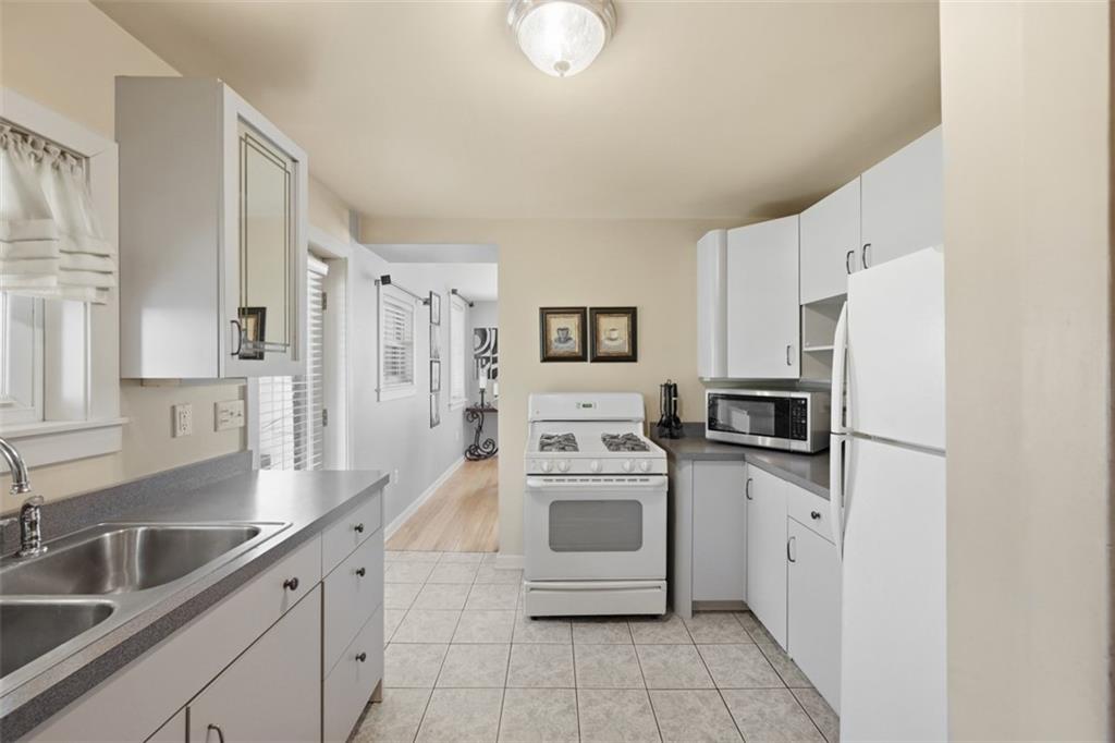 252 Berry Street Baden, PA 15005 - Photo 17 of 48 a kitchen with white cabinets and white appliances