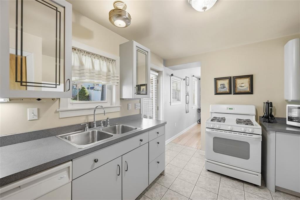 252 Berry Street Baden, PA 15005 - Photo 18 of 48 a kitchen with white cabinets and white appliances