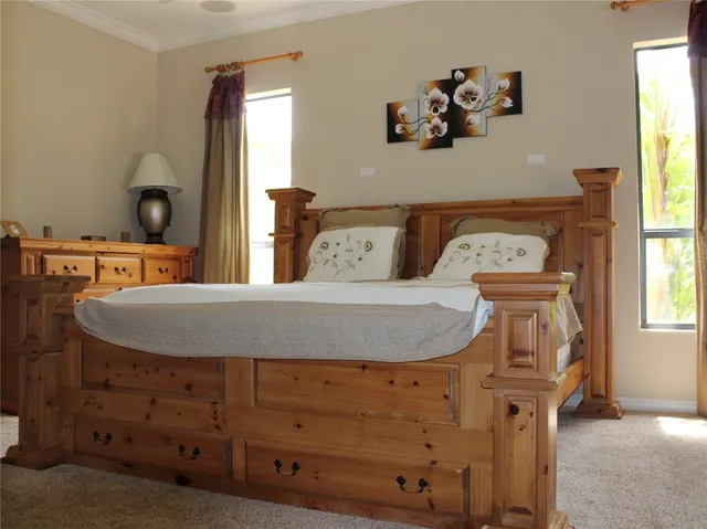 a bedroom with a bed and a painting on the wall