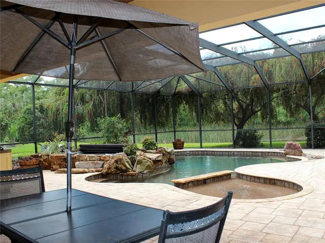 a view of backyard with a table and chairs under an umbrella