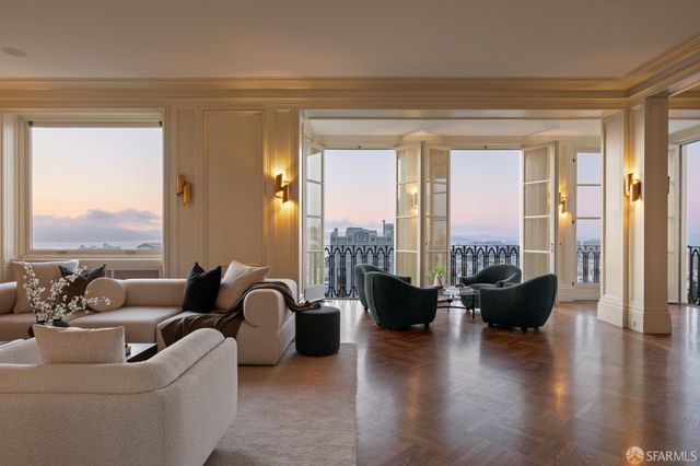 a living room with furniture floor to ceiling window and wooden floor