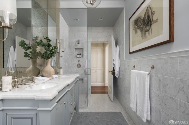 a spacious bathroom with a granite countertop sink a mirror and shower