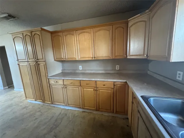 a kitchen with granite countertop cabinets stainless steel appliances and a window