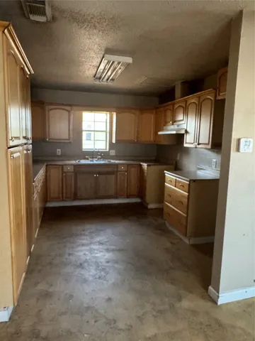 a kitchen with stainless steel appliances granite countertop a sink and a refrigerator