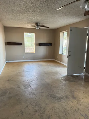 an empty room with windows and a fireplace