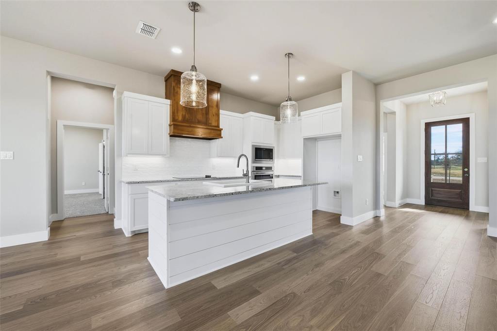 1973 Johnnie Drive Springtown, TX 76082 - Photo 12 of 38 Kitchen with white cabinetry, decorative light fixtures, dark wood-type flooring, light stone counters, and recessed lighting