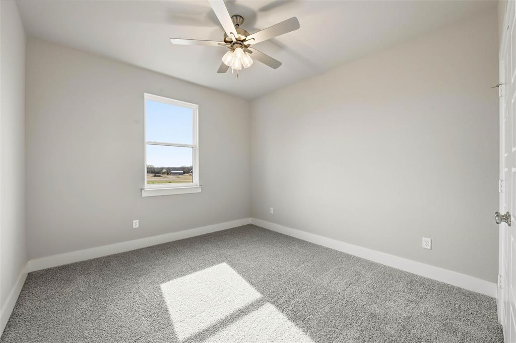 1973 Johnnie Drive Springtown, TX 76082 - Photo 18 of 38 Carpeted spare room with baseboards and a ceiling fan
