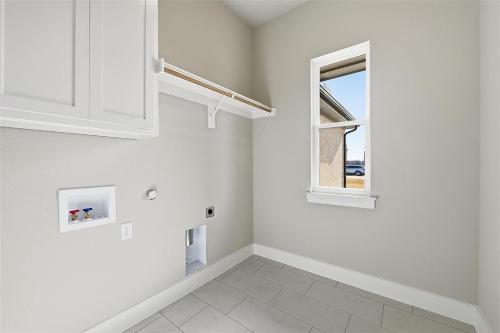 1973 Johnnie Drive Springtown, TX 76082 - Photo 27 of 38 Laundry area featuring hookup for a washing machine, electric dryer hookup, gas dryer hookup, cabinet space, and light tile patterned floors